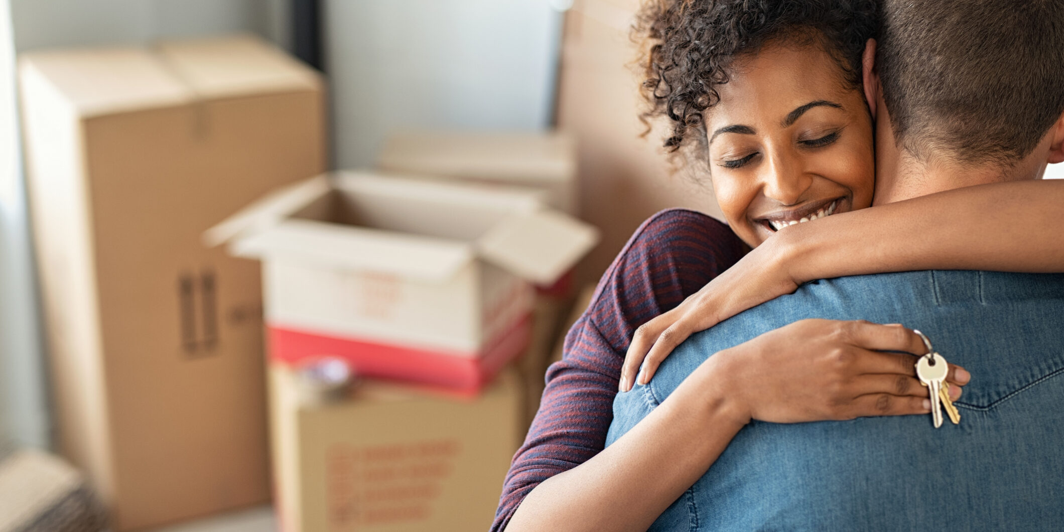 Woman hugging man and holding home keys Essential tips for first-time home buyers
