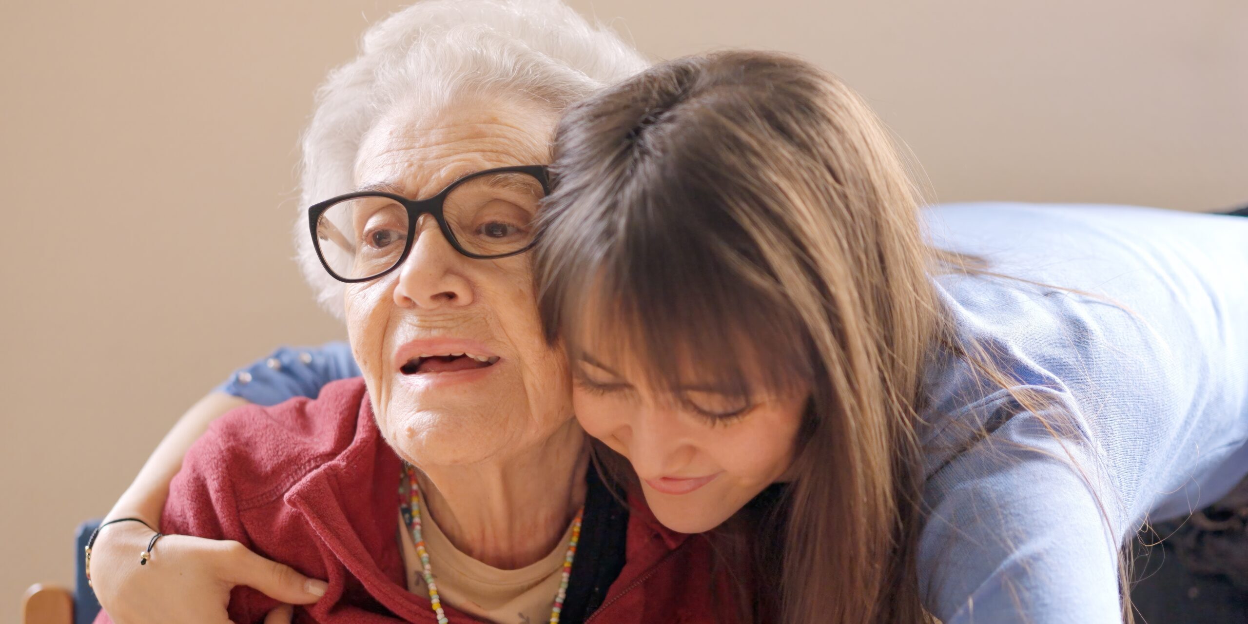 Granddaughter embracing her grandmother in a geriatric Adult children helping aging parents